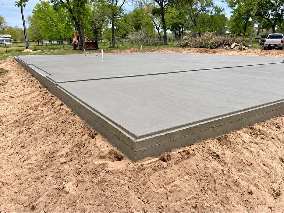 Finished concrete slab with thickened edges and plumbing pipes